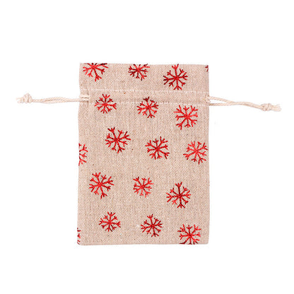 Kerstzakjes in jutelook met trekkoord en rode kerstprint met rendieren en sneeuwvlokken