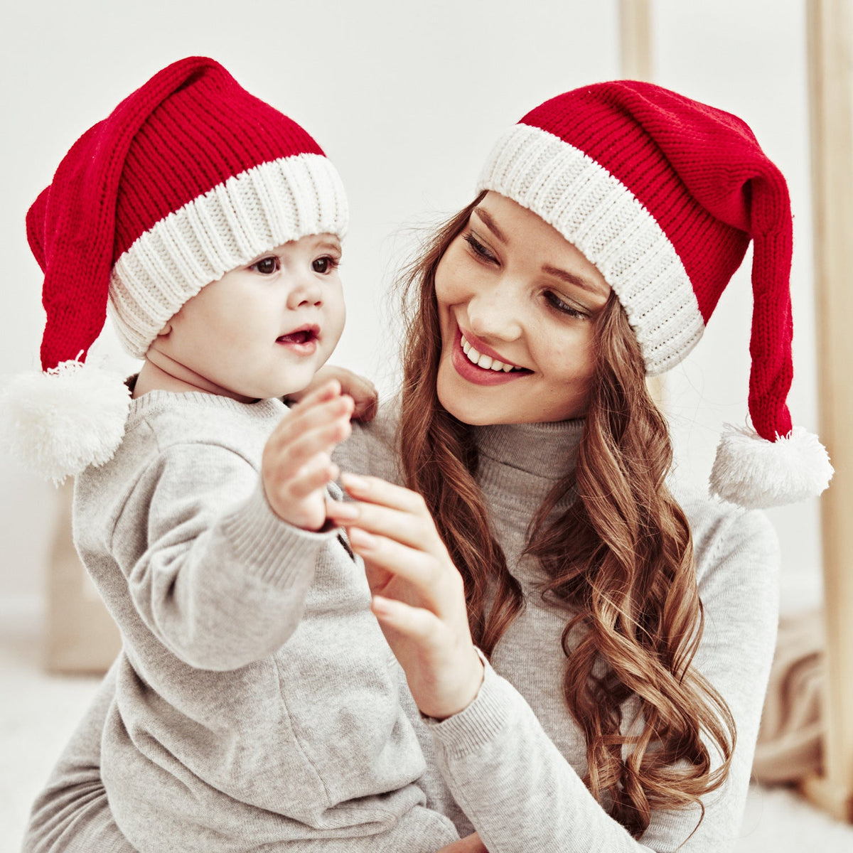 Gebreide rode kerstmuts met witte omslag en pompon, voor ouder en kind