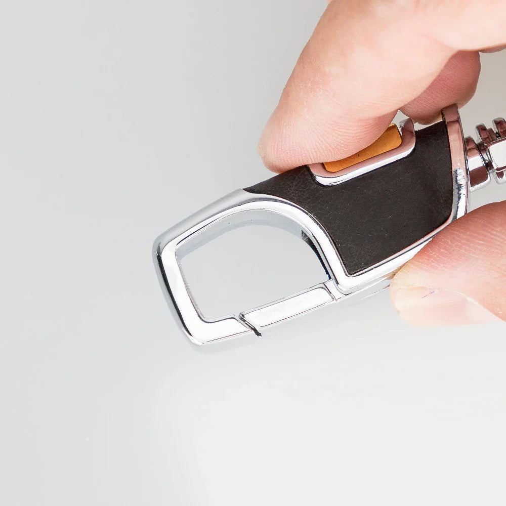 Houtskoolkleurige leren sleutelhanger in de hand met geopende veerhaak