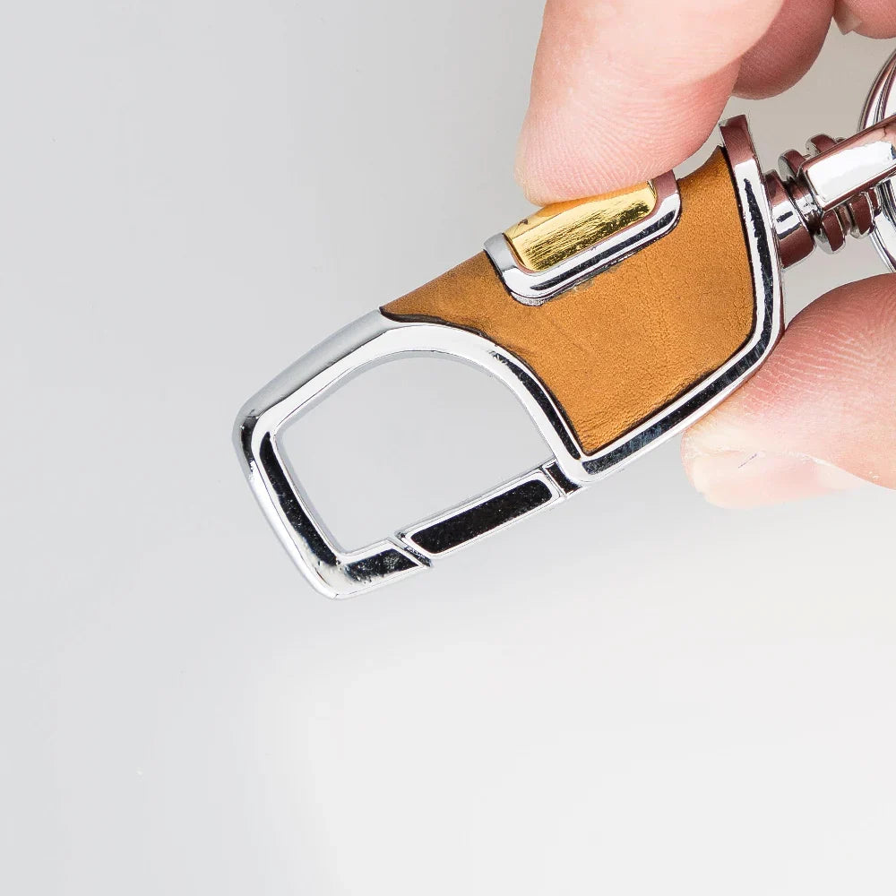 Houtskoolkleurige leren sleutelhanger in de hand met geopende veerhaak