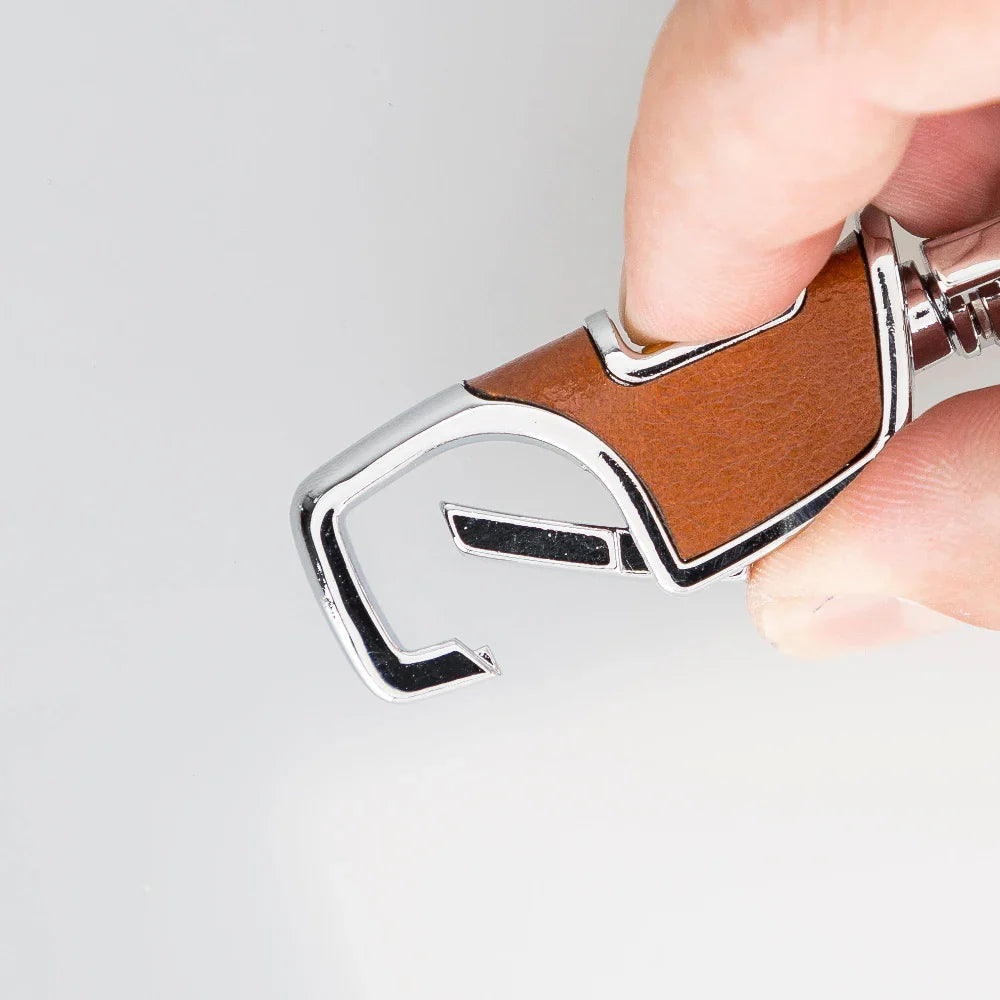 Cognac leren sleutelhanger met geopende veerhaak, leerpaneel met zichtbare nerf