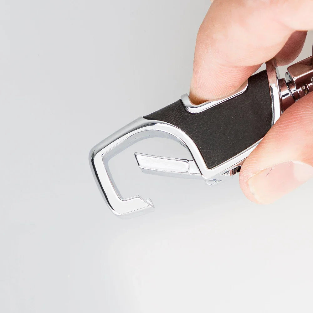 Houtskoolkleurige leren sleutelhanger in de hand met geopende veerhaak