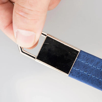 Leren sleutelhanger in de hand, gepolijste plaat naast cadetblauw leer met stiksel
