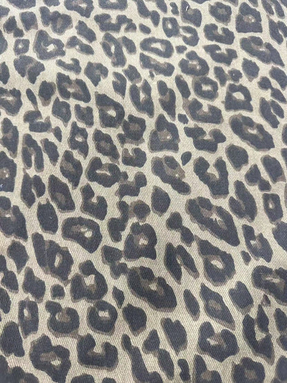 Detail van de luipaardprint op zandkleurig denim