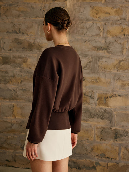 Damesvest met diepe V-hals en één goudkleurige knoop in de taille
