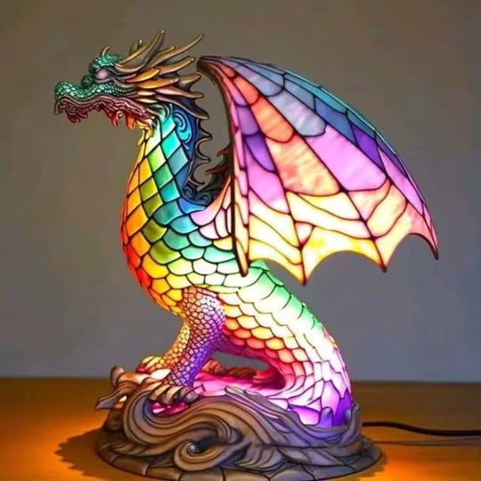 Drakenlamp in glas-in-loodlook met schubben in regenboogkleuren en roze vleugels op een voet met golven
