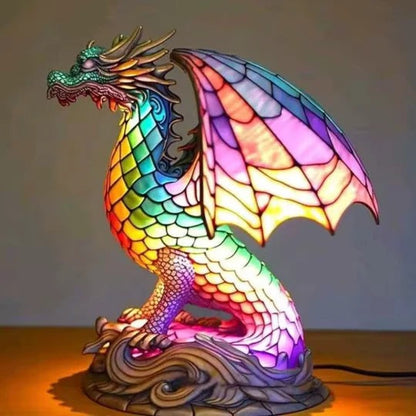 Drakenlamp in glas-in-loodlook met schubben in regenboogkleuren en roze vleugels op een voet met golven