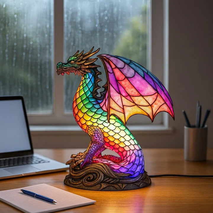 Drakenlamp in glas-in-loodlook met schubben in regenboogkleuren en roze vleugels op een voet met golven