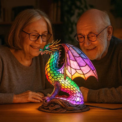 Drakenlamp in glas-in-loodlook met schubben in regenboogkleuren en roze vleugels op een voet met golven