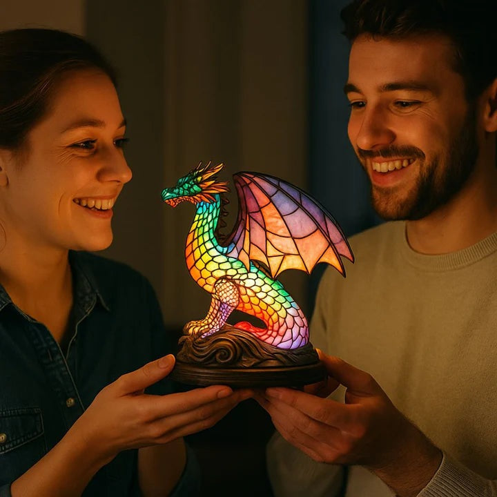 Drakenlamp in glas-in-loodlook met schubben in regenboogkleuren en roze vleugels op een voet met golven