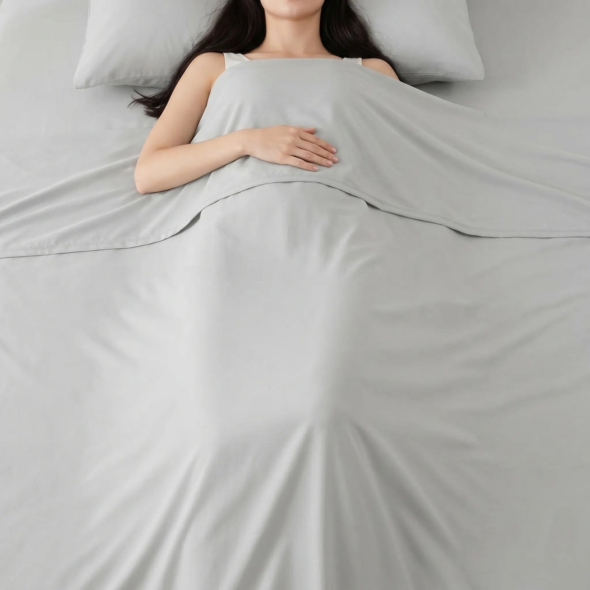 Dunne gladde zomerdeken over een slapende vrouw in bed - lichtgrijs