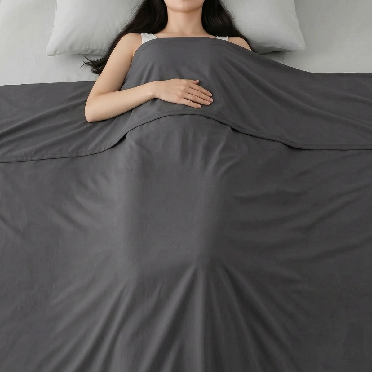 Dunne gladde zomerdeken over een slapende vrouw in bed - donkergrijs