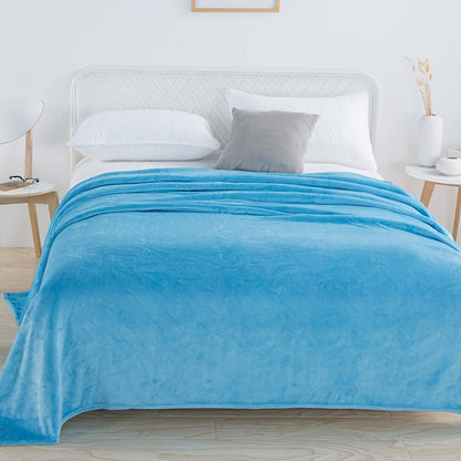 Effen fleece deken van flanel over een bed - hemelsblauw