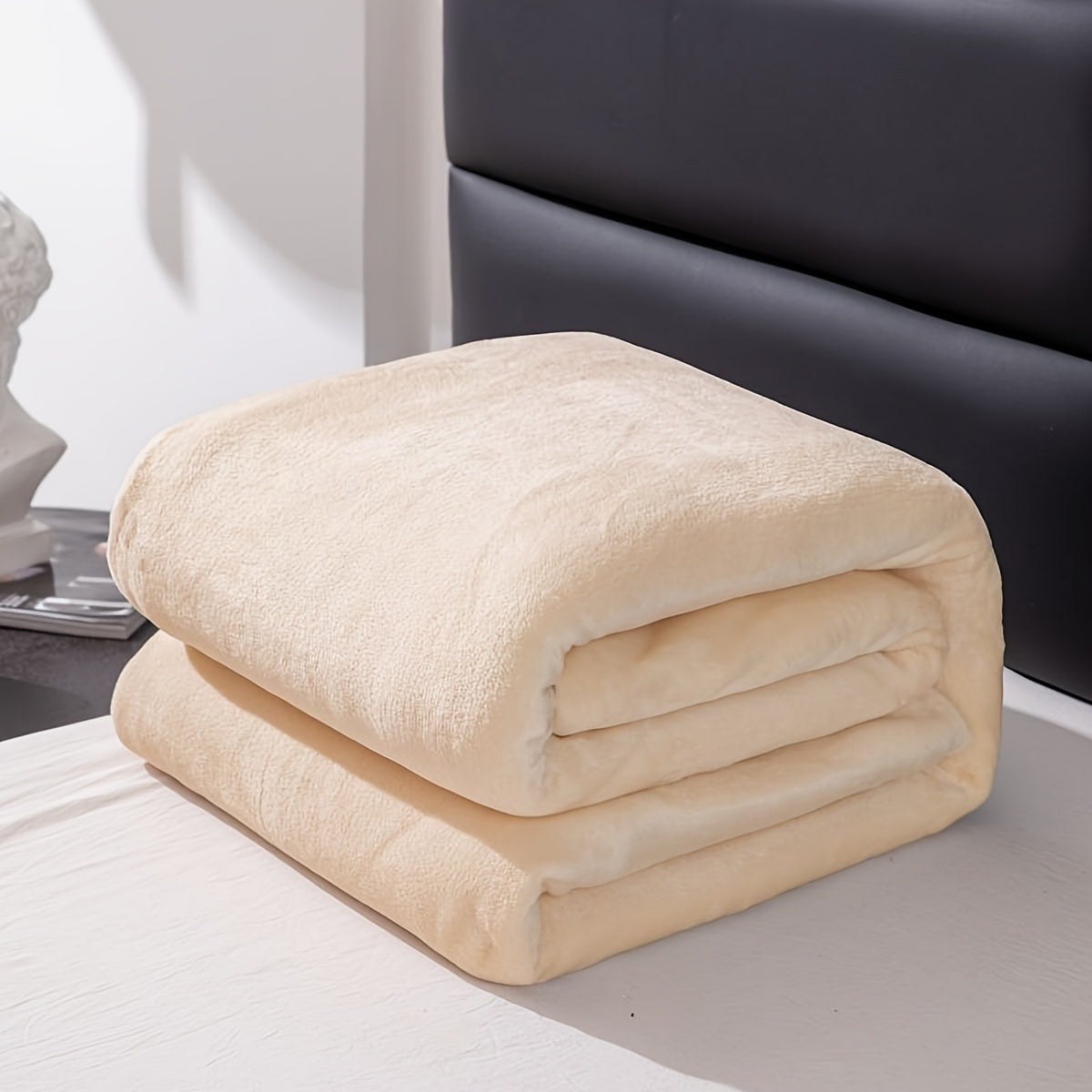 Effen fleece deken van flanel over een bed - crème