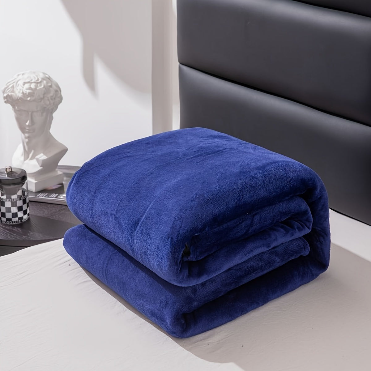Effen fleece deken van flanel over een bed - koningsblauw