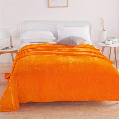 Effen fleece deken van flanel over een bed - oranje
