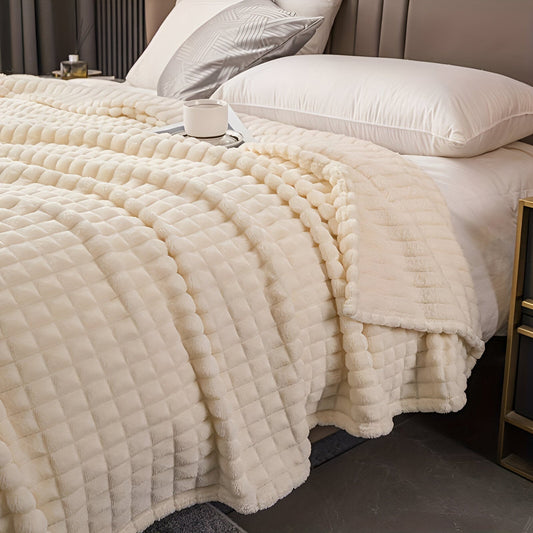 Fleece deken van koraalfleece met blokjesreliëf over een bed - crème