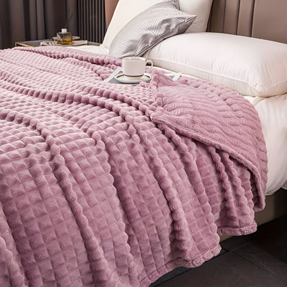 Fleece deken van koraalfleece met blokjesreliëf over een bed - mauve