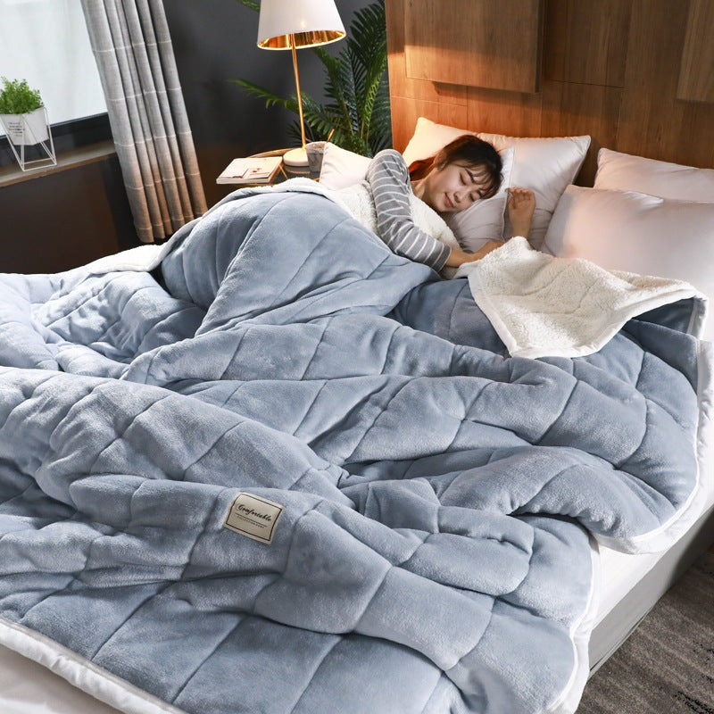 Doorgestikte fleece deken met sherpa achterkant op bed - blauwgrijs