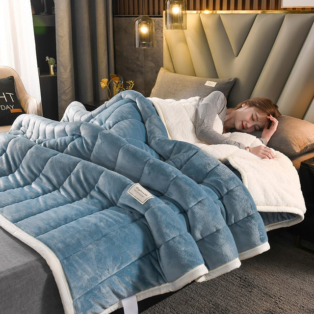 Doorgestikte fleece deken met sherpa achterkant op bed - staalblauw