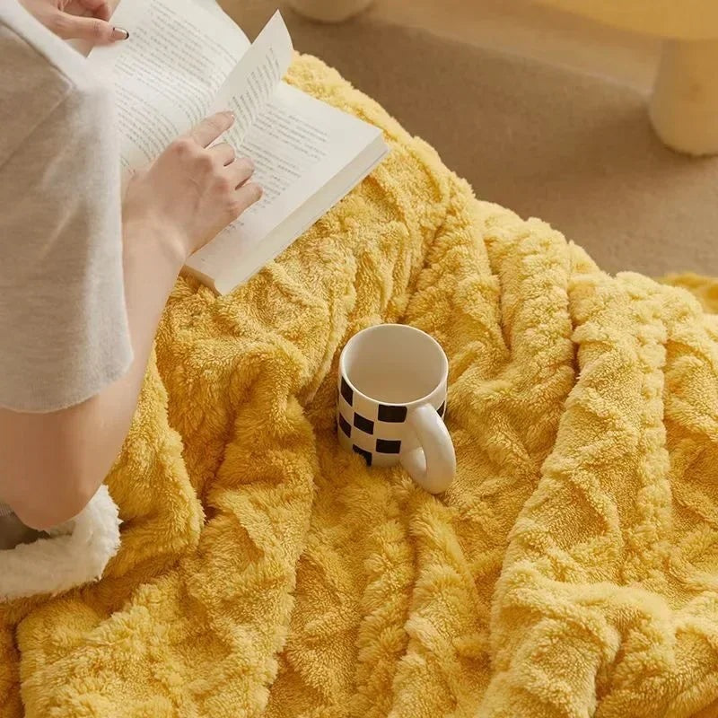 Fleece deken met teddy binnenkant en reliëfpatroon op een tweepersoonsbed - geel