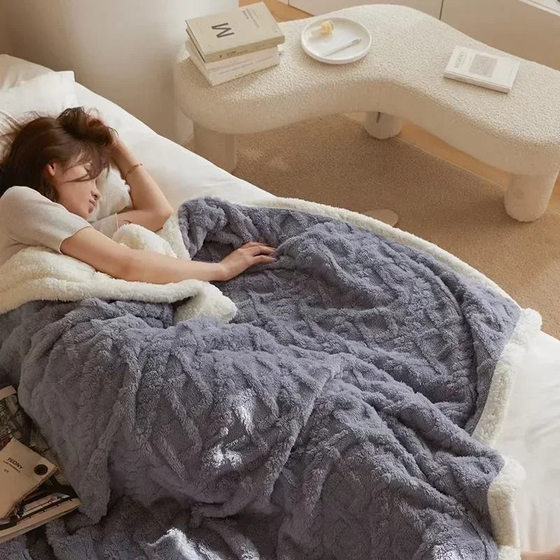 Fleece deken met teddy binnenkant en reliëfpatroon op een tweepersoonsbed - grijsblauw