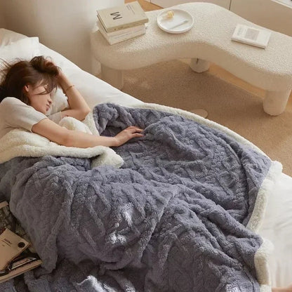 Fleece deken met teddy binnenkant en reliëfpatroon op een tweepersoonsbed - grijsblauw