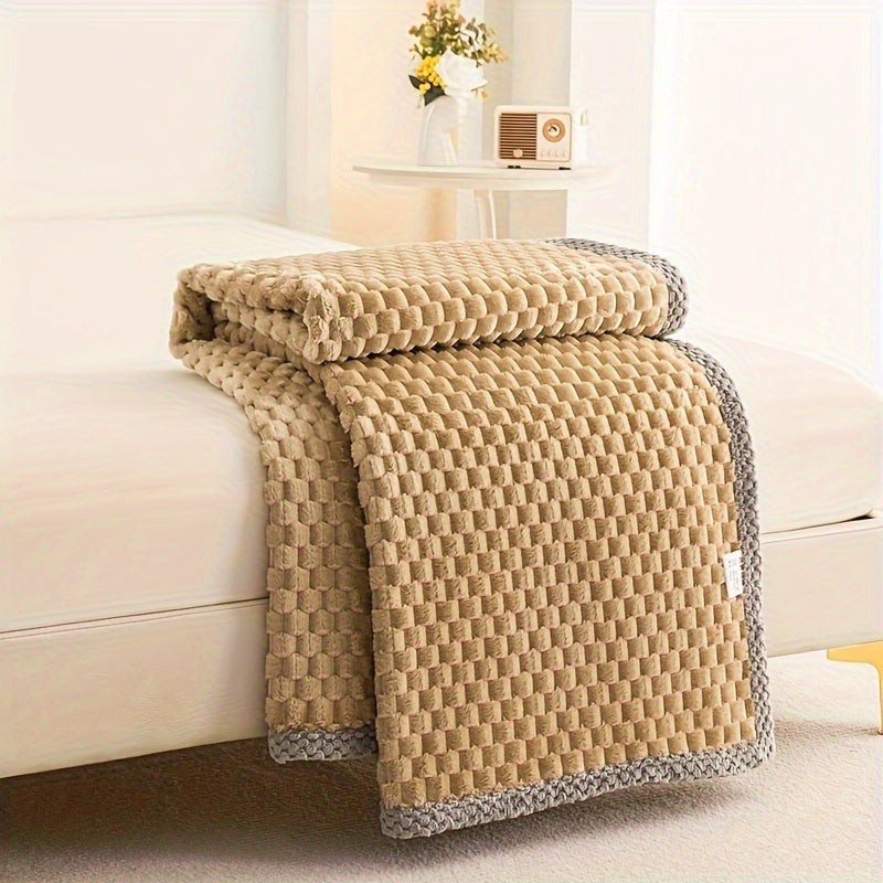 Fleece plaid met blokreliëf en een gebreide rand over de rand van een bed - camel