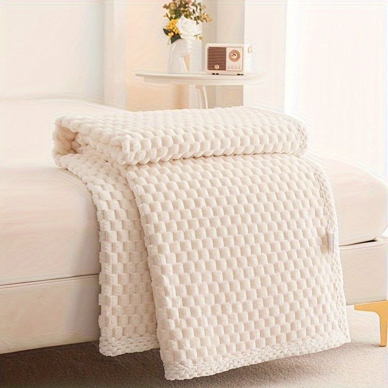 Fleece plaid met blokreliëf en een gebreide rand over de rand van een bed - crème