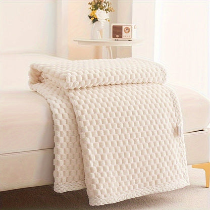 Fleece plaid met blokreliëf en een gebreide rand over de rand van een bed - crème