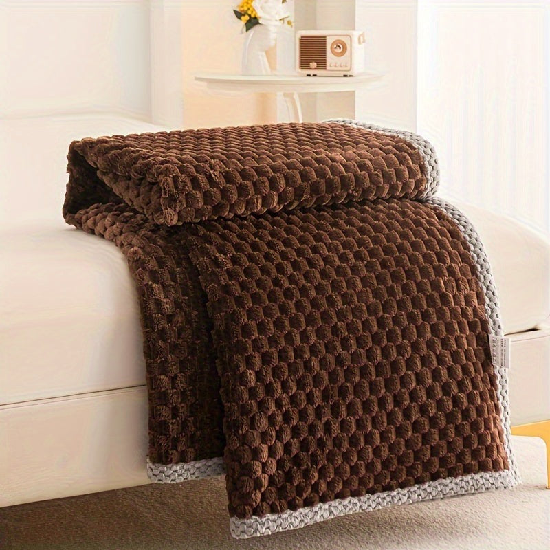 Fleece plaid met blokreliëf en een gebreide rand over de rand van een bed - chocoladebruin
