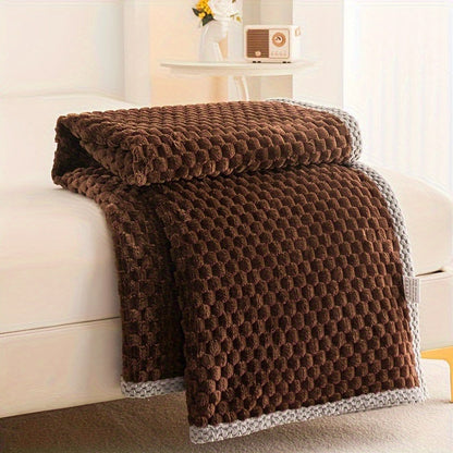 Fleece plaid met blokreliëf en een gebreide rand over de rand van een bed - chocoladebruin