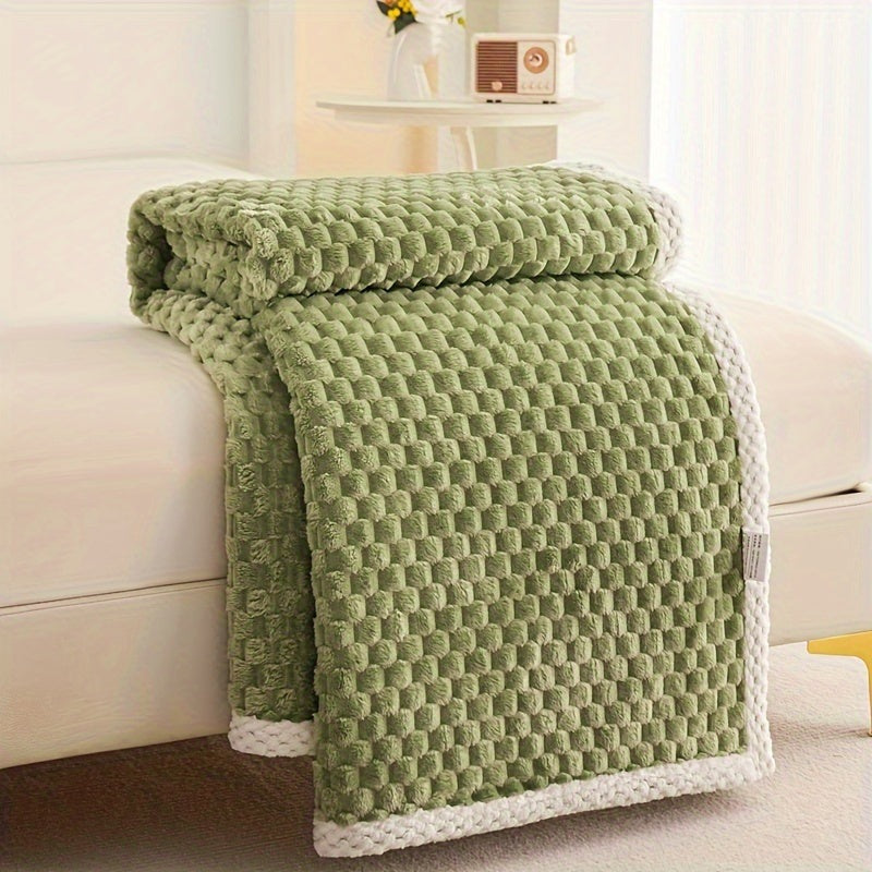 Fleece plaid met blokreliëf en een gebreide rand over de rand van een bed - olijfgroen