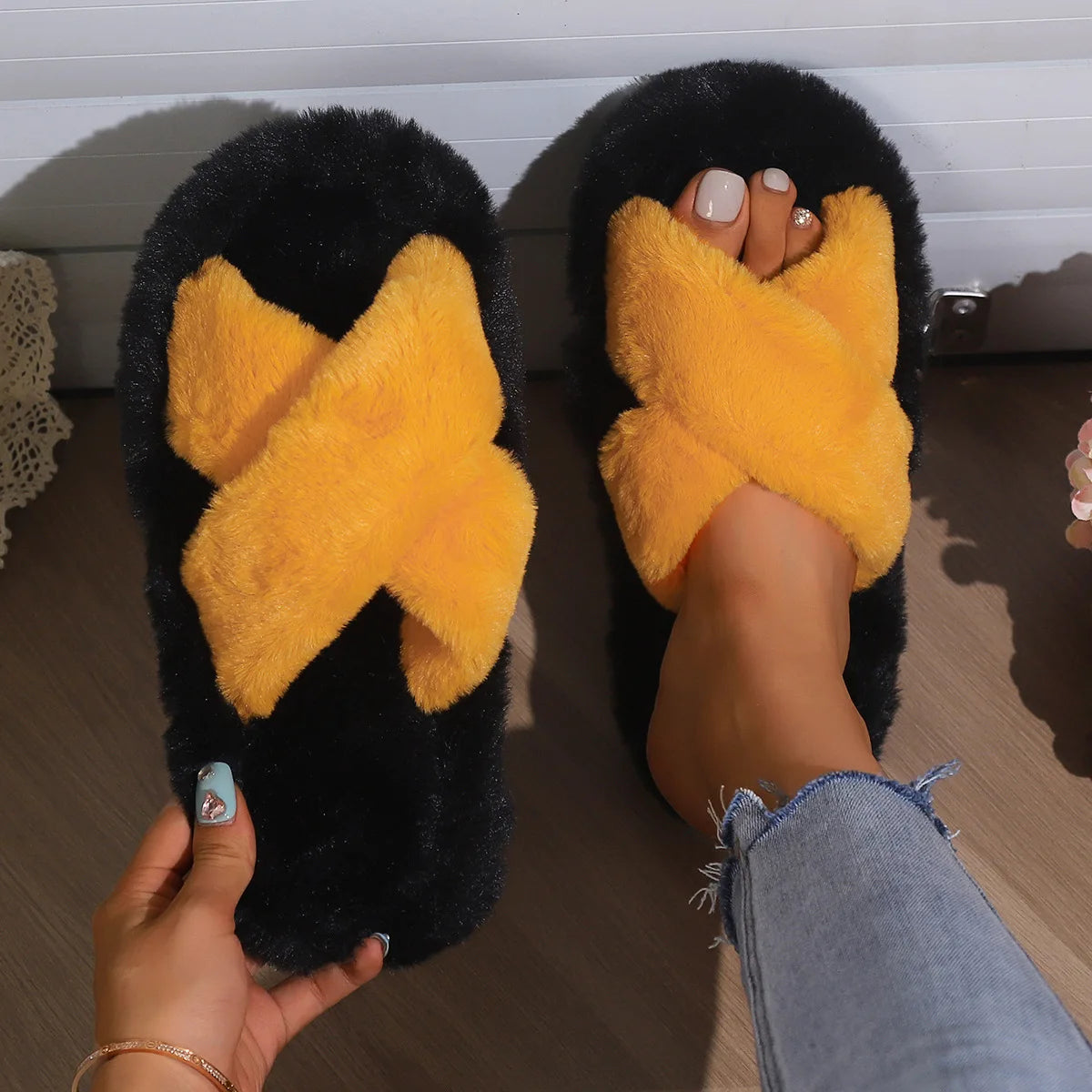 Fluffy slippers met gekruiste pluche banden in contrastkleur op zwart pluche voetbed - oranje