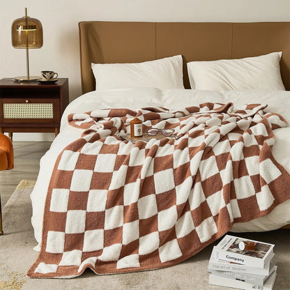 Gebreide plaid van teddy met dambordpatroon over een fauteuil - terracotta