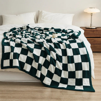 Gebreide plaid van teddy met dambordpatroon over een fauteuil - donkergroen