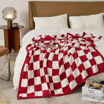Gebreide plaid van teddy met dambordpatroon over een fauteuil - rood
