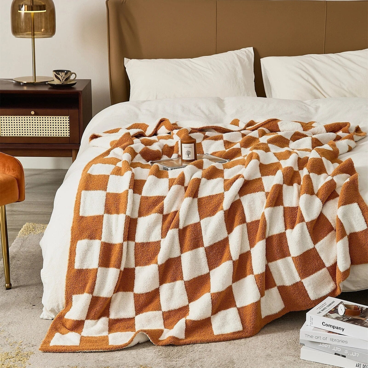 Gebreide plaid van teddy met dambordpatroon over een fauteuil - roestoranje