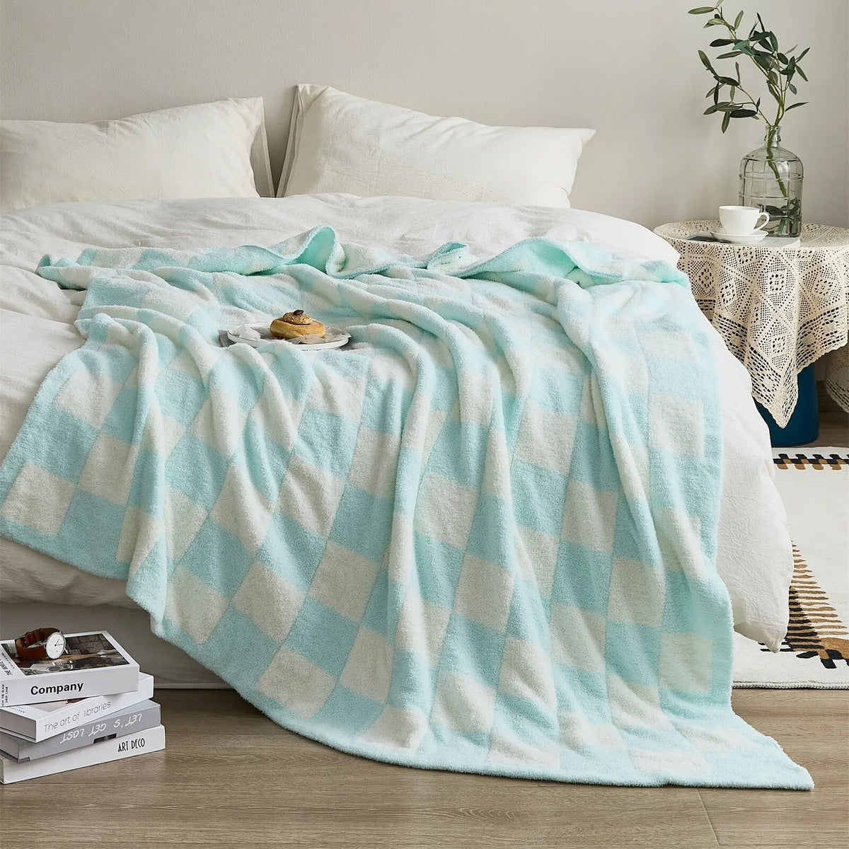 Gebreide plaid van teddy met dambordpatroon over een fauteuil - lichtblauw