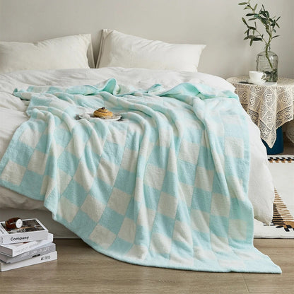 Gebreide plaid van teddy met dambordpatroon over een fauteuil - lichtblauw
