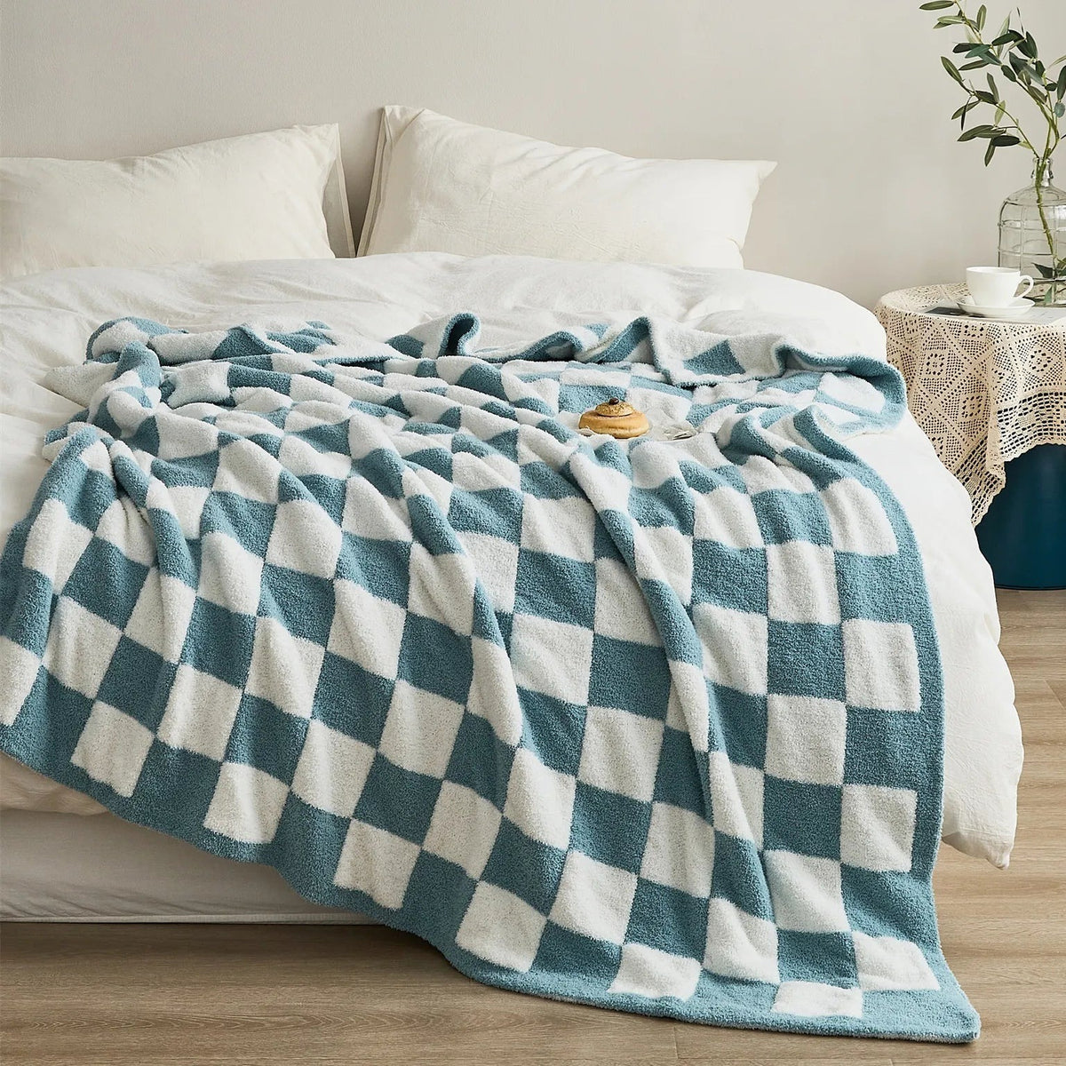 Gebreide plaid van teddy met dambordpatroon over een fauteuil - petrolblauw