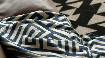 Gebreide plaid met geometrisch patroon over een bruine bank - beeld 5