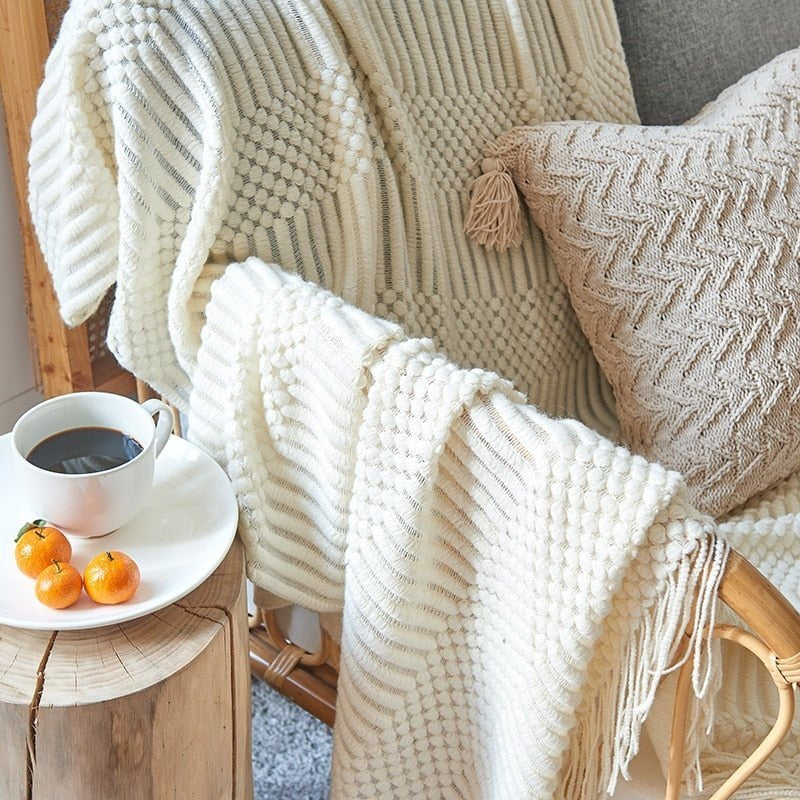 Gebreide plaid met Scandinavisch patroon en franjes over een stoel - crème