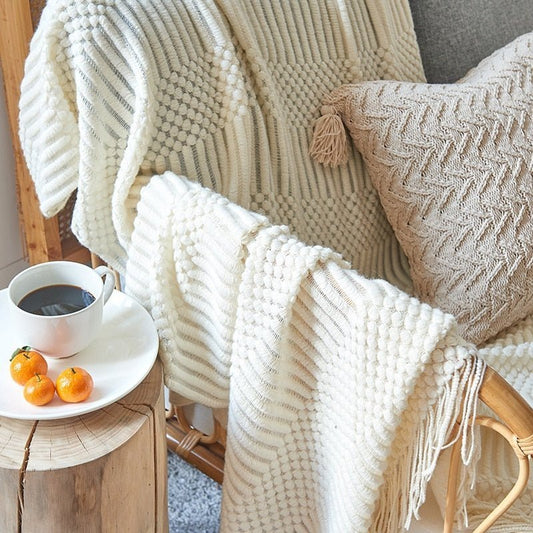 Gebreide plaid met Scandinavisch patroon en franjes over een stoel - crème