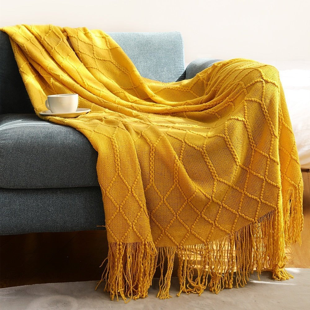 Gebreide plaid met Scandinavisch patroon en franjes over een stoel - mosterdgeel