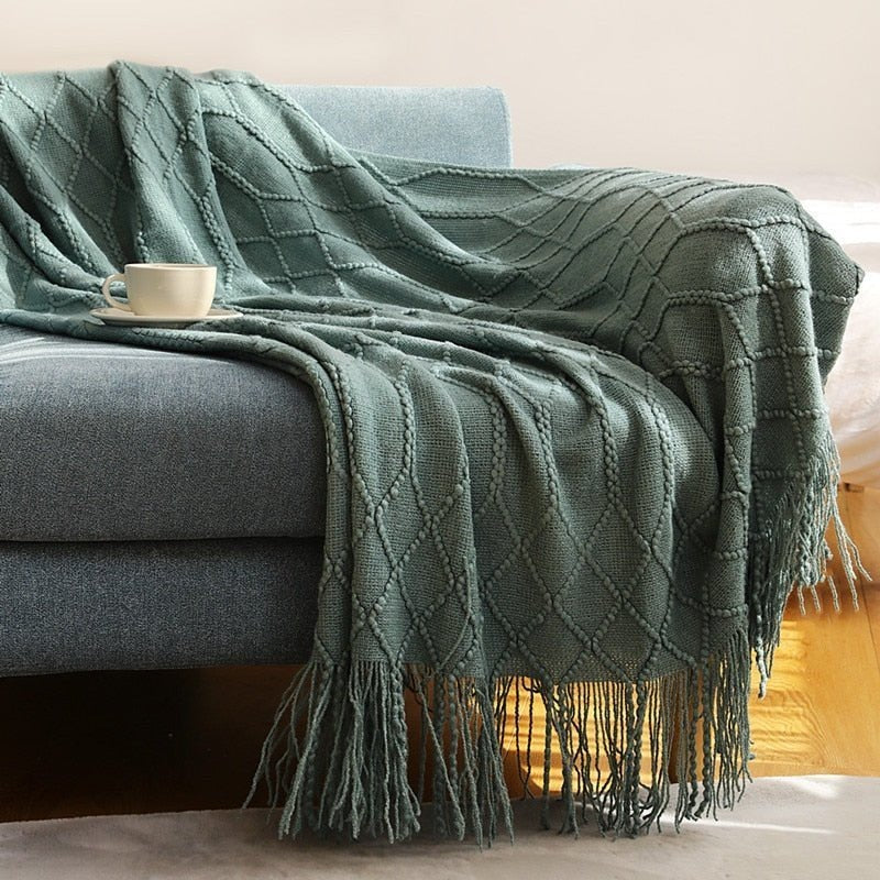 Gebreide plaid met Scandinavisch patroon en franjes over een stoel - donkergroen
