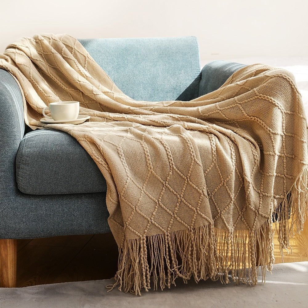 Gebreide plaid met Scandinavisch patroon en franjes over een stoel - kameel
