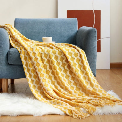 Gebreide plaid met Scandinavisch patroon en franjes over een stoel - geel-wit zigzag