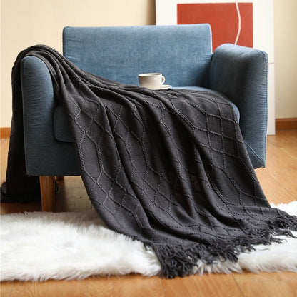 Gebreide plaid met Scandinavisch patroon en franjes over een stoel - zwart