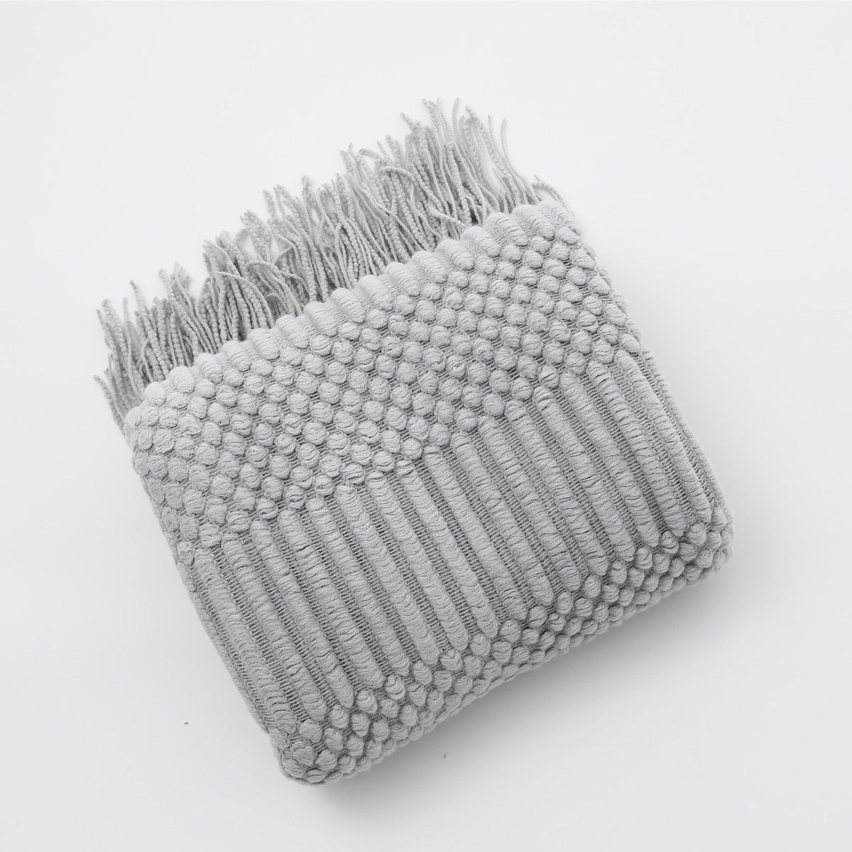 Gebreide plaid met Scandinavisch patroon en franjes over een stoel - lichtgrijs